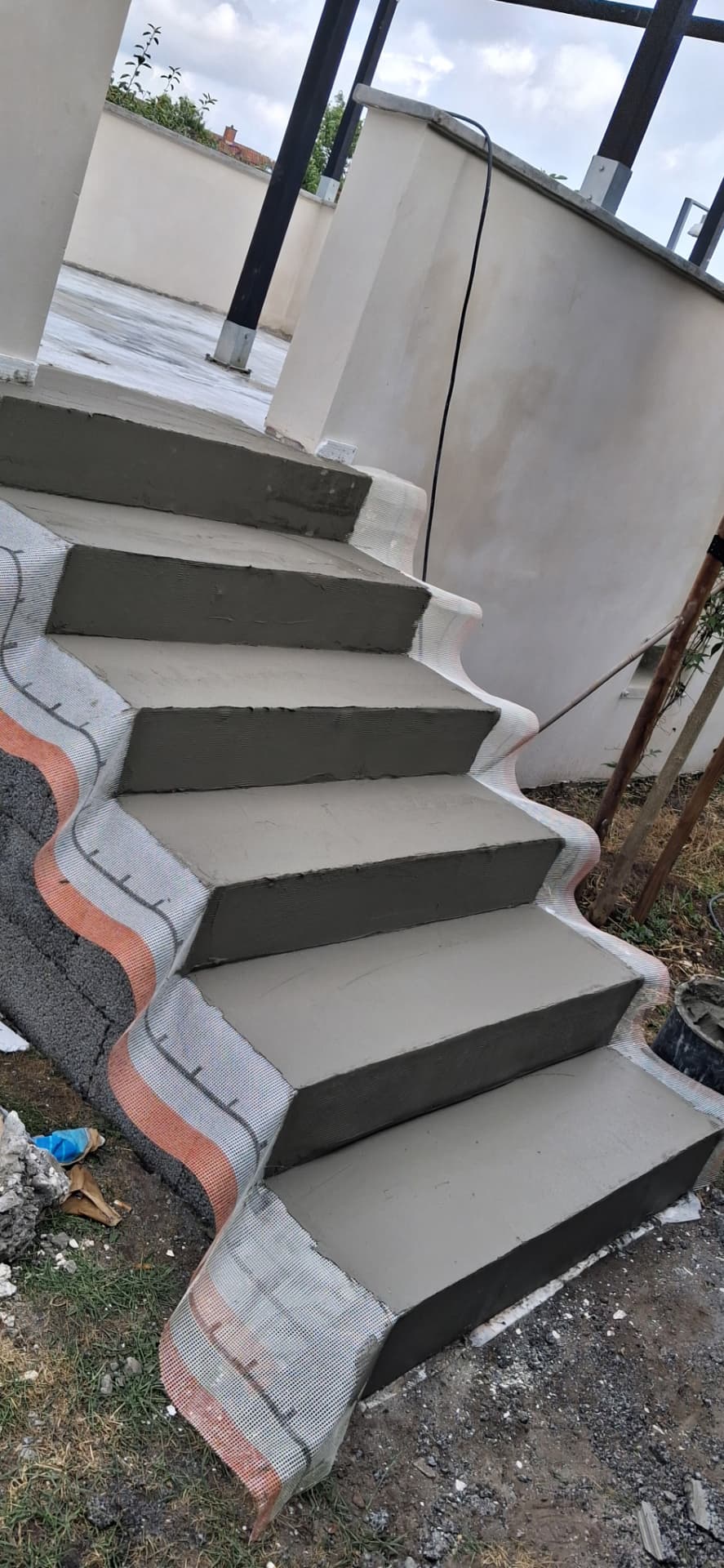 Udvendig betontrappe under opbygning med afrettede trin og armeringsnet i mørtel