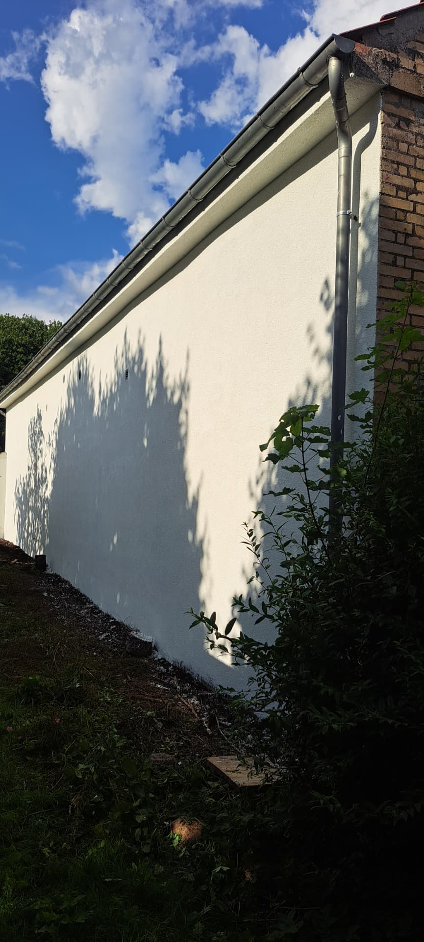 Facade efter renovering med ny puds malet i lys tone