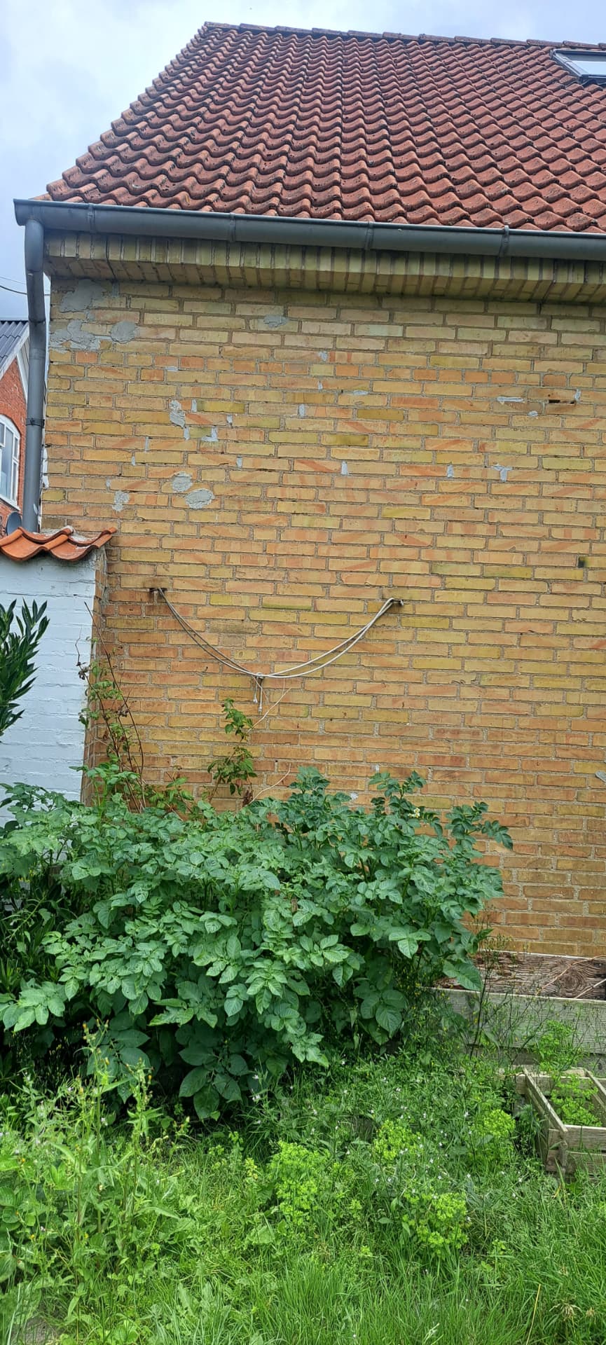 Murstensfacade før renovering med pletvise mørtelreparationer